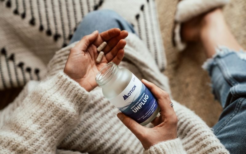 person holding blue and white labeled plastic bottle