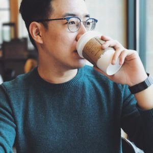 man holding Starbucks disposable cup